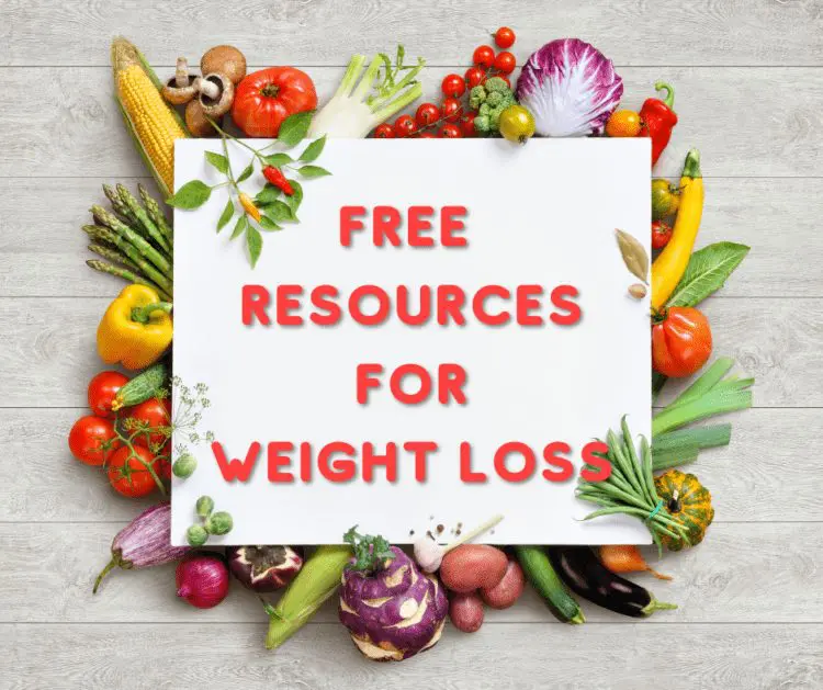 Free keto weight loss resources sign surrounded by fresh low-carb vegetables on a wooden table