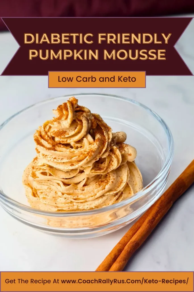 A visually appealing bowl of Easy Pumpkin Mousse Fluff, which is keto-friendly, sugar-free, and low-carb. The mousse is piped into a swirl, topped with a sprinkle of cinnamon, and accompanied by two cinnamon sticks, all set against a clean, marbled background.