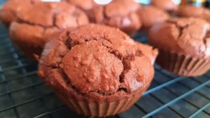 Close up of freshly baked keto chocolate muffins on a wire cooling rack.