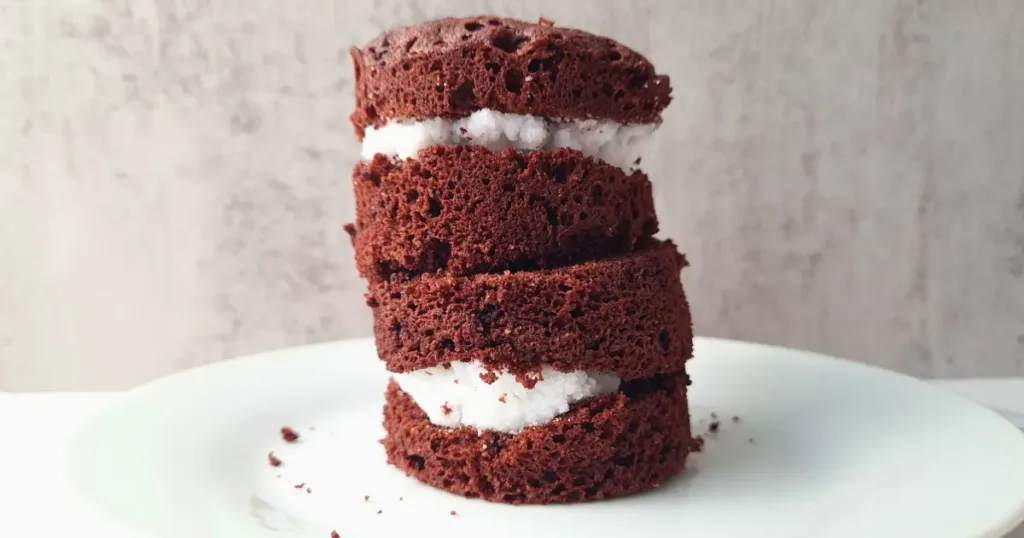 A delicious Keto Oreo Mug Cake with a rich, chocolatey flavor and creamy filling, served on a white plate beside a mug with ‘Have A Mug Cake’ written on it.