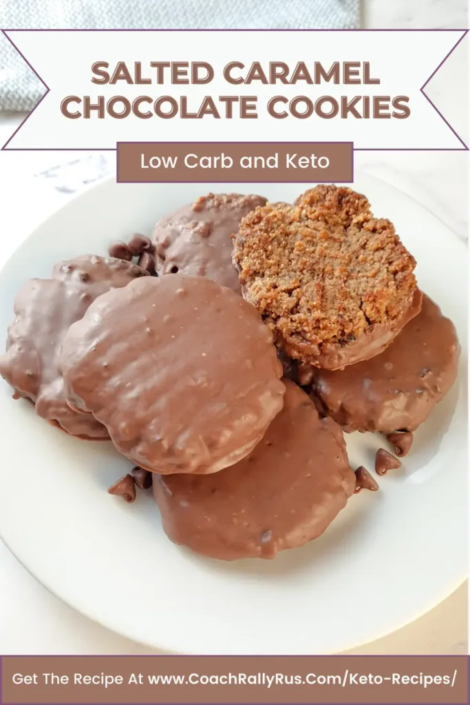 A mouthwatering close-up of Keto Salted Caramel Chocolate Cookies, with one cookie cut in half to reveal the soft and gooey caramel filling, and the rest of the cookies covered in melted chocolate. These cookies are grain and gluten free, and have only 3.5g net carbs per cookie.