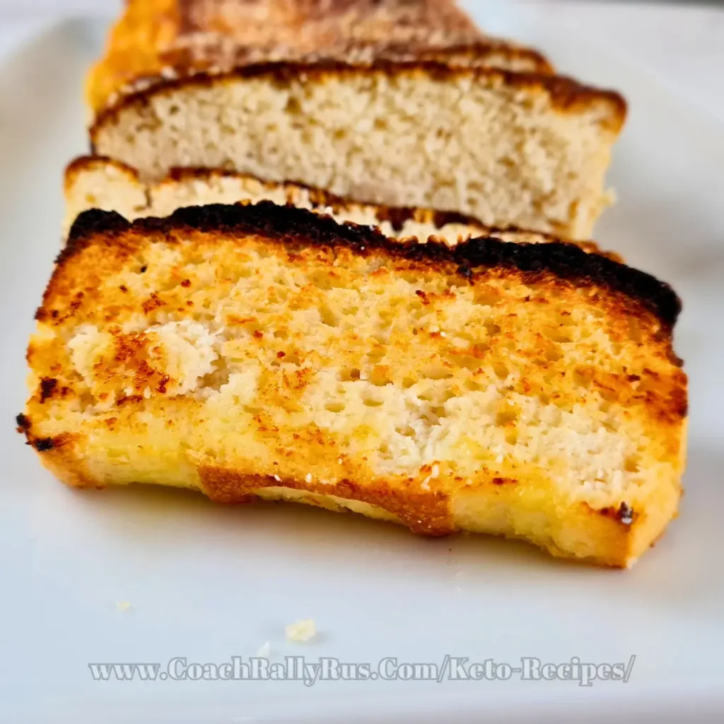 A freshly baked loaf of keto-friendly Cottage Cheese Bread with Almond Flour, showcasing a golden-brown crust and a soft, airy interior, served on a white plate.