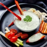 A creamy and inviting bowl of Keto Ranch Dip with Cottage Cheese, garnished with fresh herbs, ready to be enjoyed with a colorful selection of vegetable sticks.