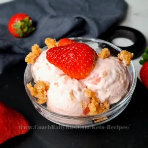 A sumptuous scoop of Keto Strawberry Cottage Cheese Ice Cream, topped with a juicy strawberry and sprinkled with a nutty crumble, served in a stylish dessert bowl, embodying a perfect fusion of health and taste for a low-carb indulgence.