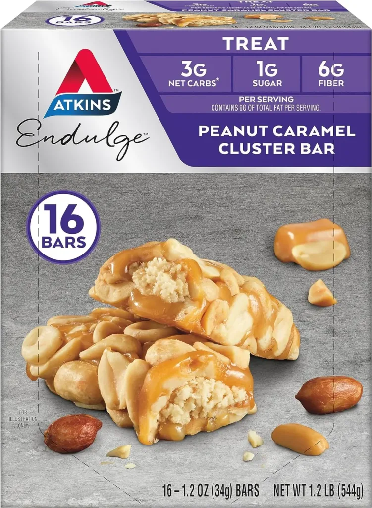 An Atkins Endulge Treat Peanut Caramel Cluster Bar box, containing 16 bars with 3g net carbs, 1g sugar, and 6g fiber per serving. The image also features an opened bar with visible peanuts and caramel, emphasizing the treat’s indulgent yet health-conscious ingredients.