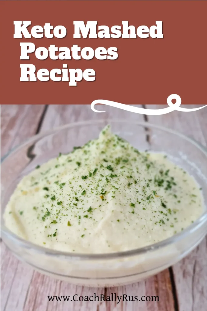 A bowl of creamy Keto Cauliflower Mash topped with green herbs, presented on a wooden surface with the text ‘Keto Mashed Potatoes Recipe’ and the website ‘www.CoachRallyRus.com’ displayed above.