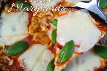 A close-up image of a Cottage Cheese Flatbread Pizza Margherita, showcasing a high-protein, keto-friendly meal. The pizza features golden-brown crust edges with melted mozzarella slices and vibrant green basil leaves on top of a rich tomato sauce.
