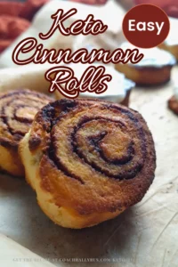 A close-up image of freshly baked Keto Cinnamon Rolls made with coconut flour, presented on a wooden surface. The rolls have a golden-brown exterior with a visible swirl pattern of cinnamon filling. The text overlay at the top reads “Keto Cinnamon Rolls” in white and “Easy” in an orange circle.