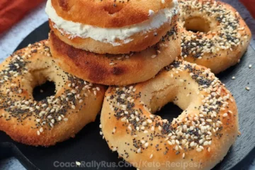 A stack of golden-brown cottage cheese bagels topped with various seeds on a plate.