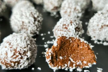 Keto-friendly chocolate rum balls coated with coconut, made with cottage cheese.