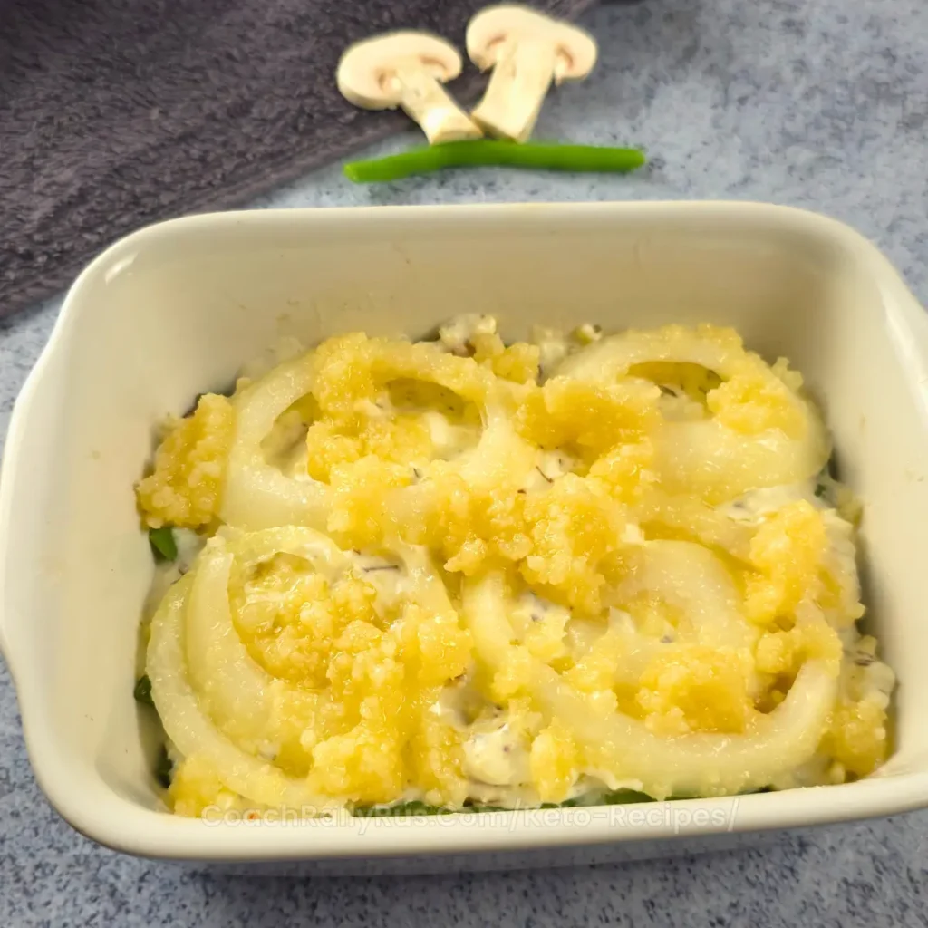 Keto Green Bean and Mushroom Casserole topped with crispy onions in a white baking dish.