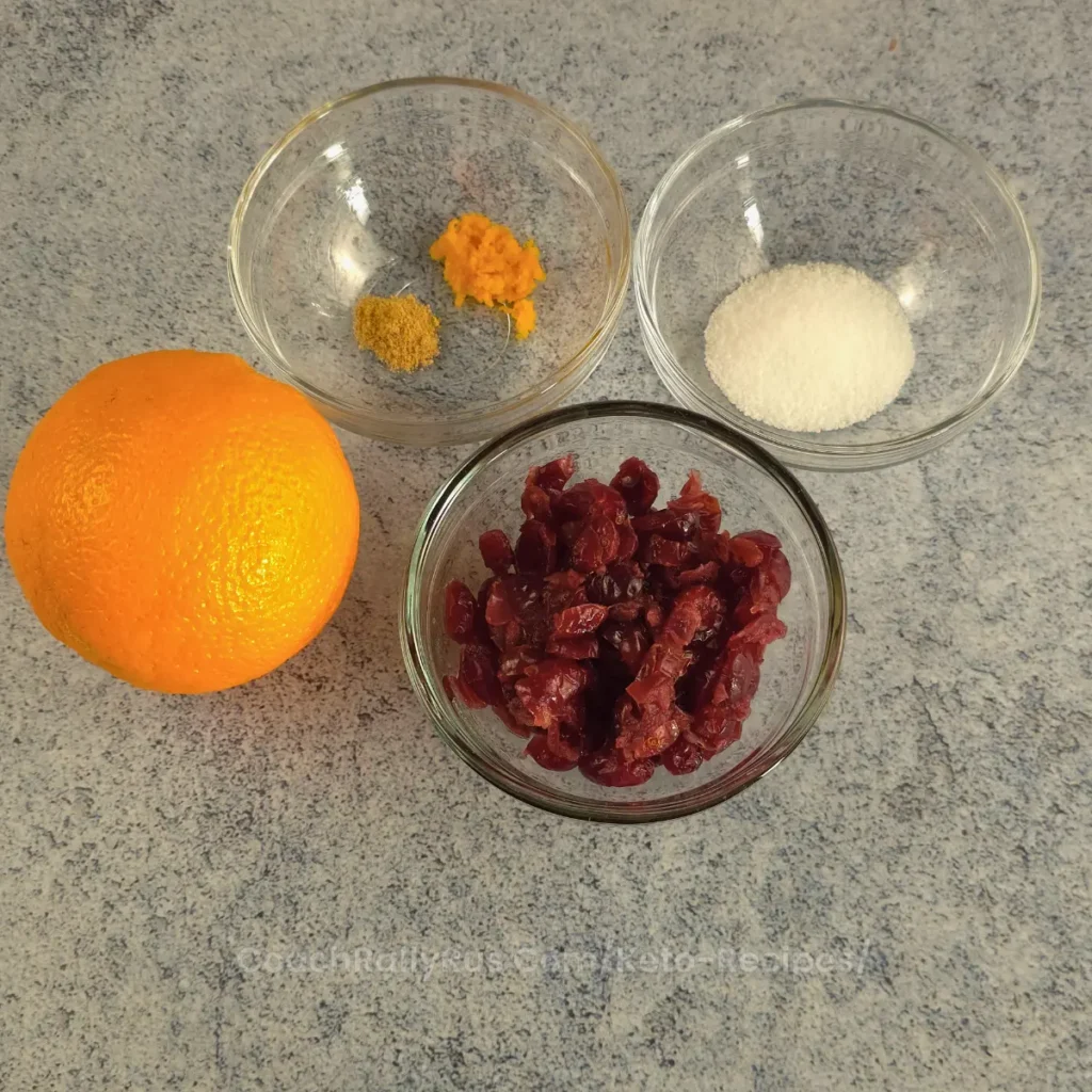 Ingredients for Spiced Keto Cranberry-Orange Relish, including dried cranberries, orange zest, ginger, and keto sweetener.
