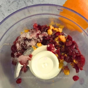 Dried cranberries, orange zest, and ginger blended in a food processor for a keto cranberry relish recipe.