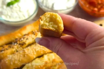 A bite of keto garlic parmesan breadstick showing the soft, cheesy interior.