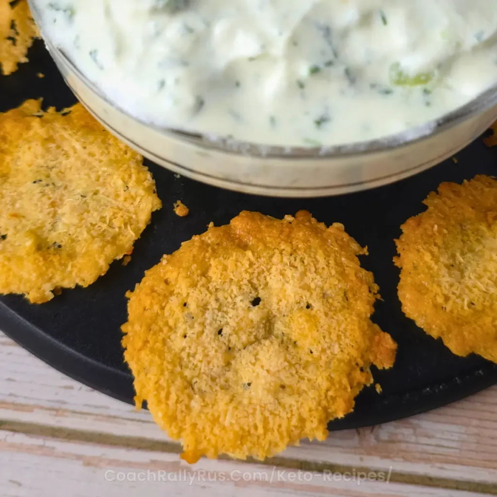 Close-up of crispy parmesan cheese crisps with seasoning, served with dip