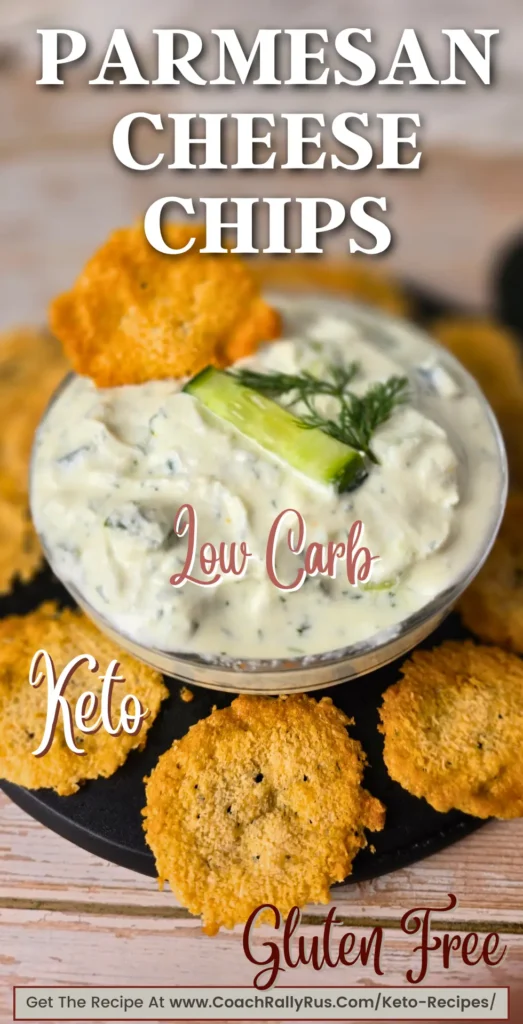 Crispy golden parmesan cheese chips on a black plate with a creamy cucumber dip.