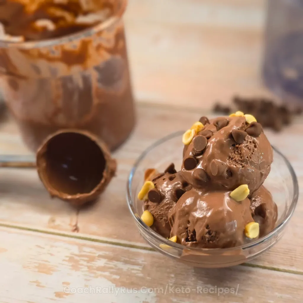 Scooped keto chocolate peanut butter ice cream with peanuts and chocolate chips