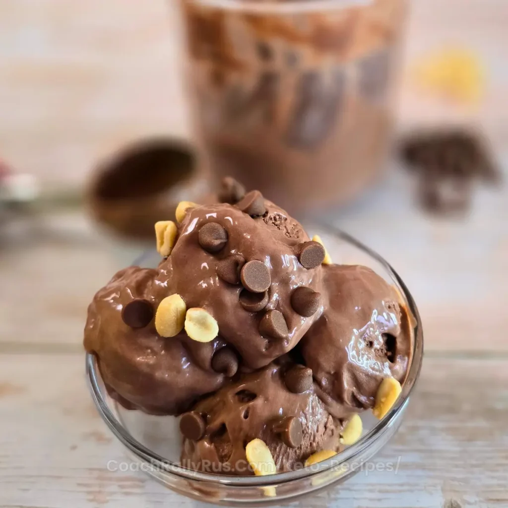 Creamy chocolate peanut butter ice cream in glass bowl beside Ninja Creami container