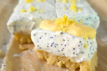 Close-up of a sliced keto lemon poppy seed cottage cheese bar topped with lemon zest.