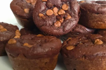 Stack of cottage cheese keto chocolate brownie muffins on a white plate