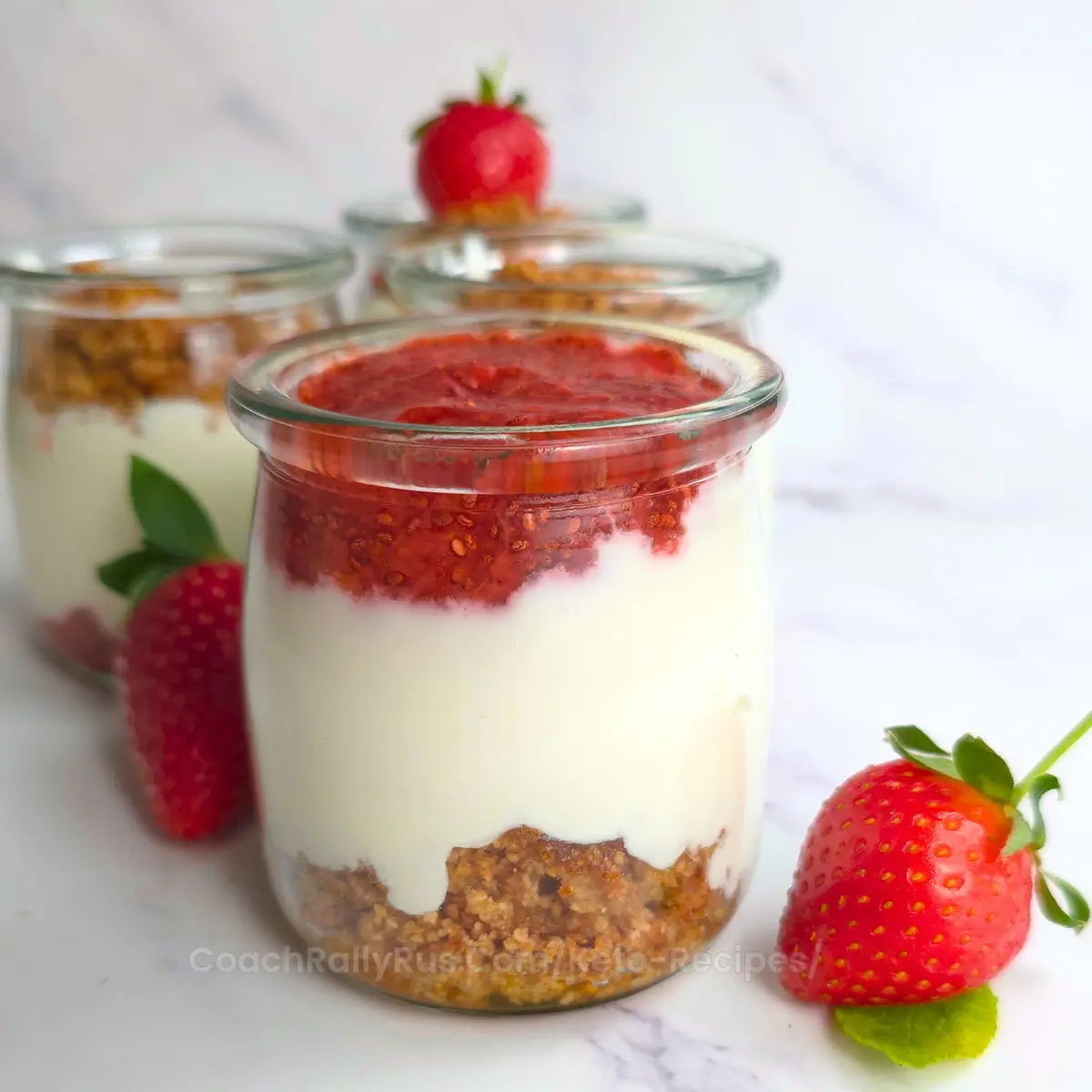 Cottage cheese parfait layered with strawberry jam and crumble in clear jars