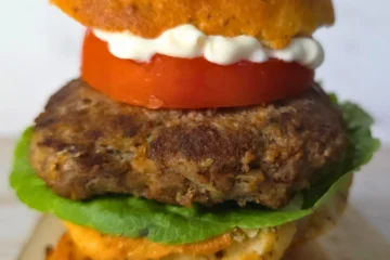Juicy keto Mediterranean burger on a bun with lettuce, tomato, and mayo