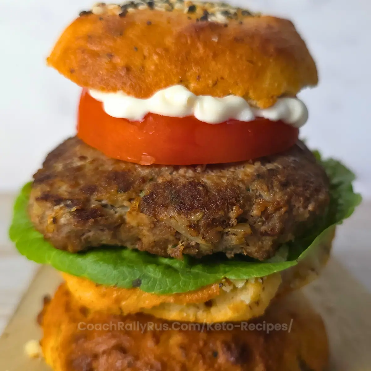 Juicy keto Mediterranean burger on a bun with lettuce, tomato, and mayo