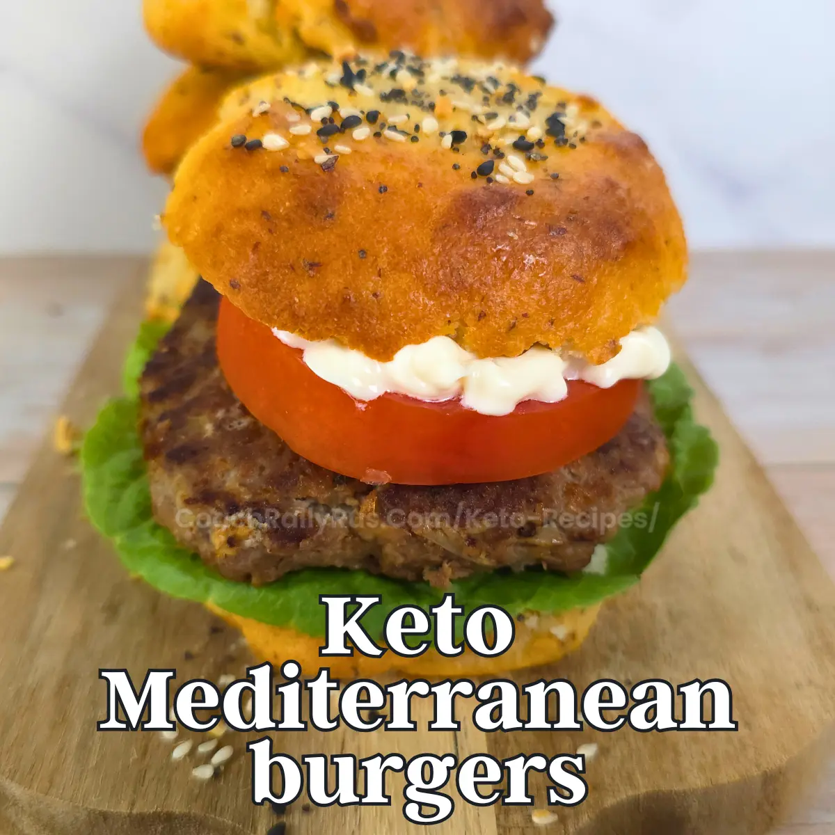Keto Mediterranean burger stacked with bun, tomato, mayo, and lettuce
