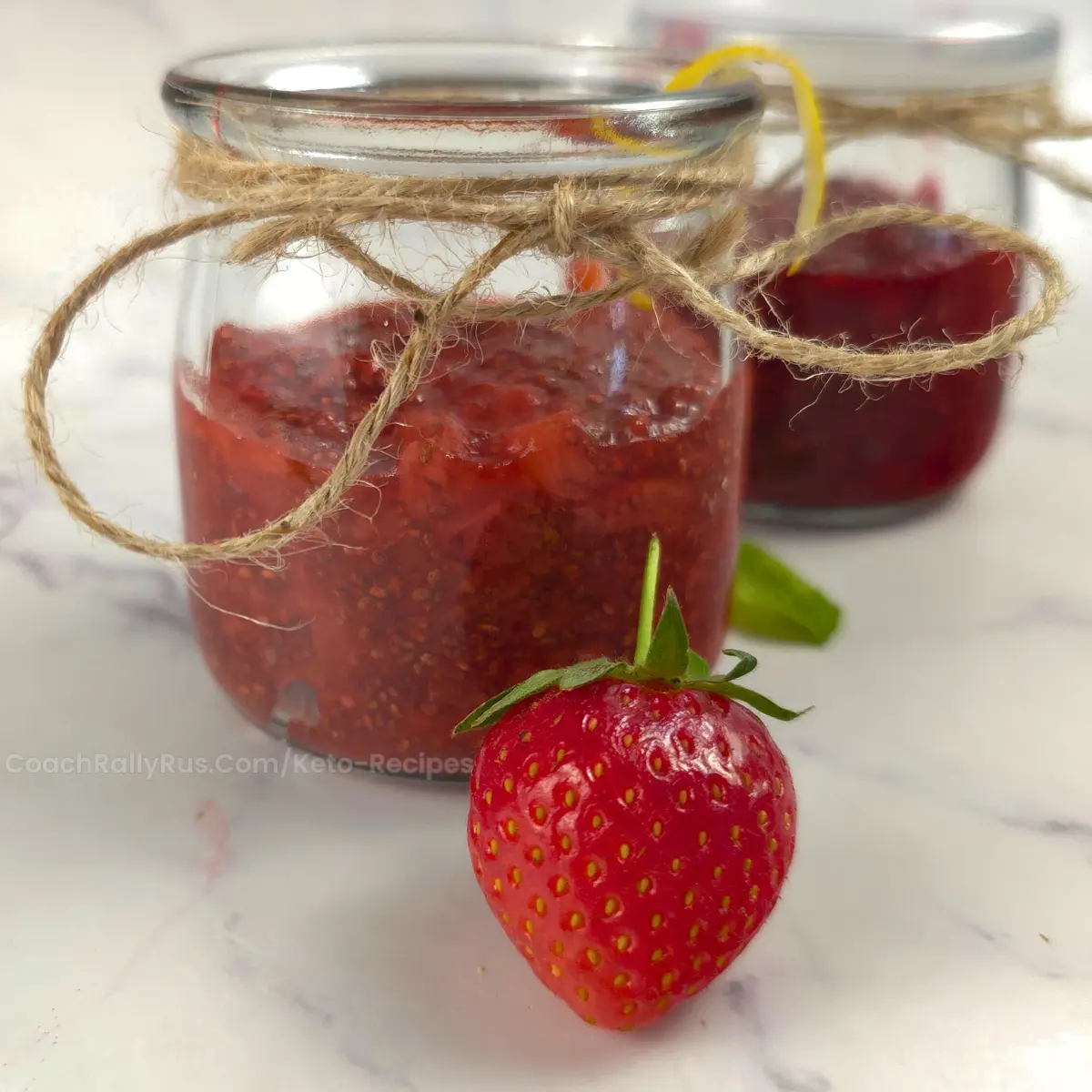 Keto jam jar with twine and whole strawberries with lemon zest