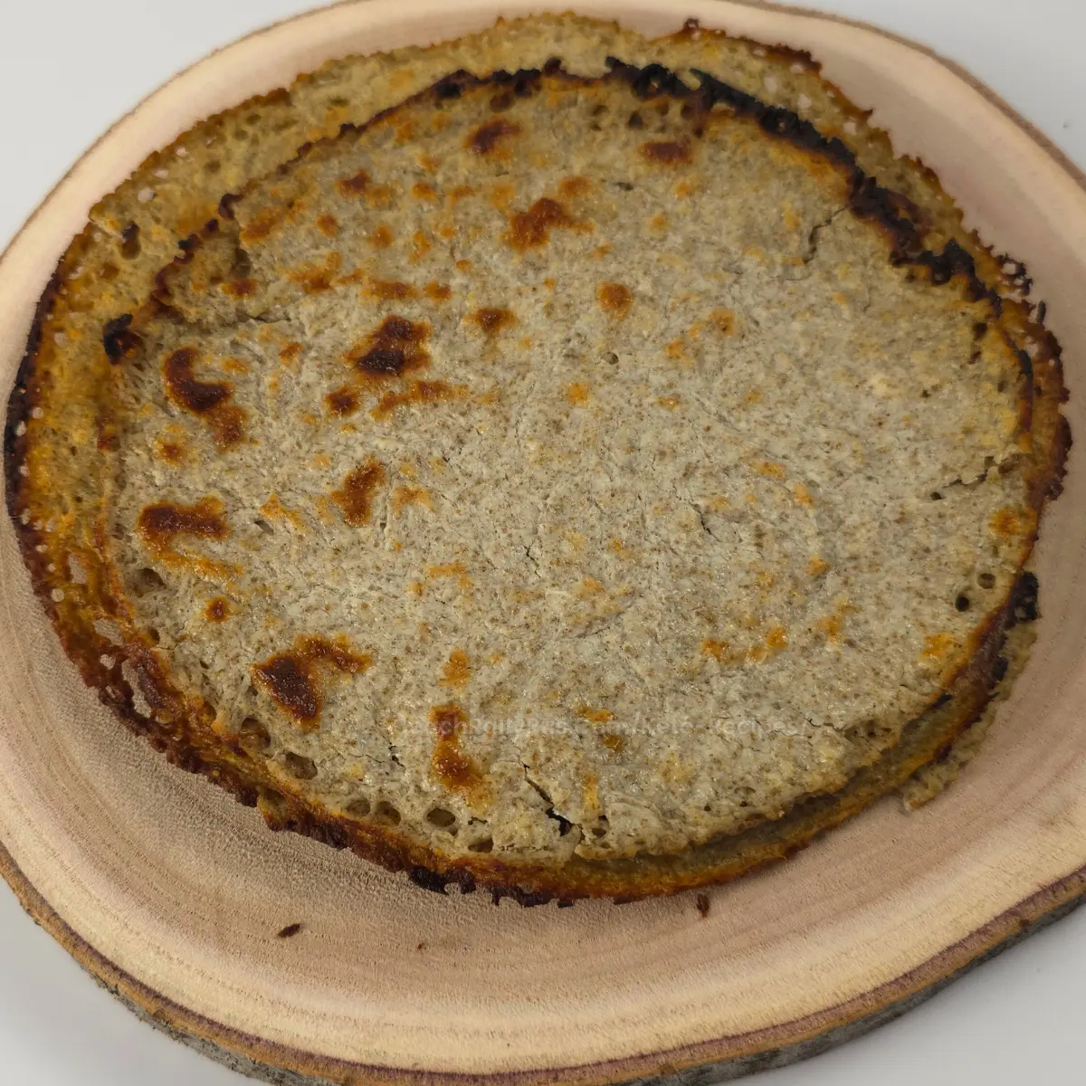 stack of cottage cheese chia seed flatbreads on wooden plate