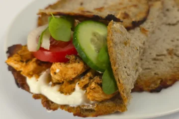 keto cottage cheese wrap filled with chicken, cucumber, tomato, and sauce