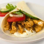 Keto chicken gyros wrap with cottage cheese, tomato, onion, and arugula