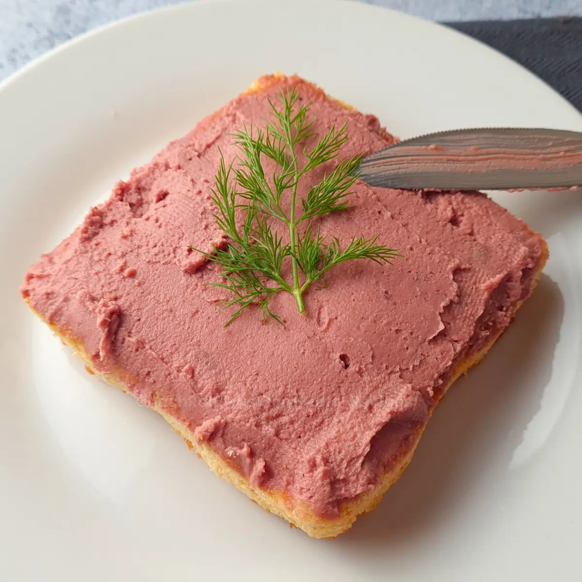 Smooth keto chicken liver pate spread on toast with fresh dill