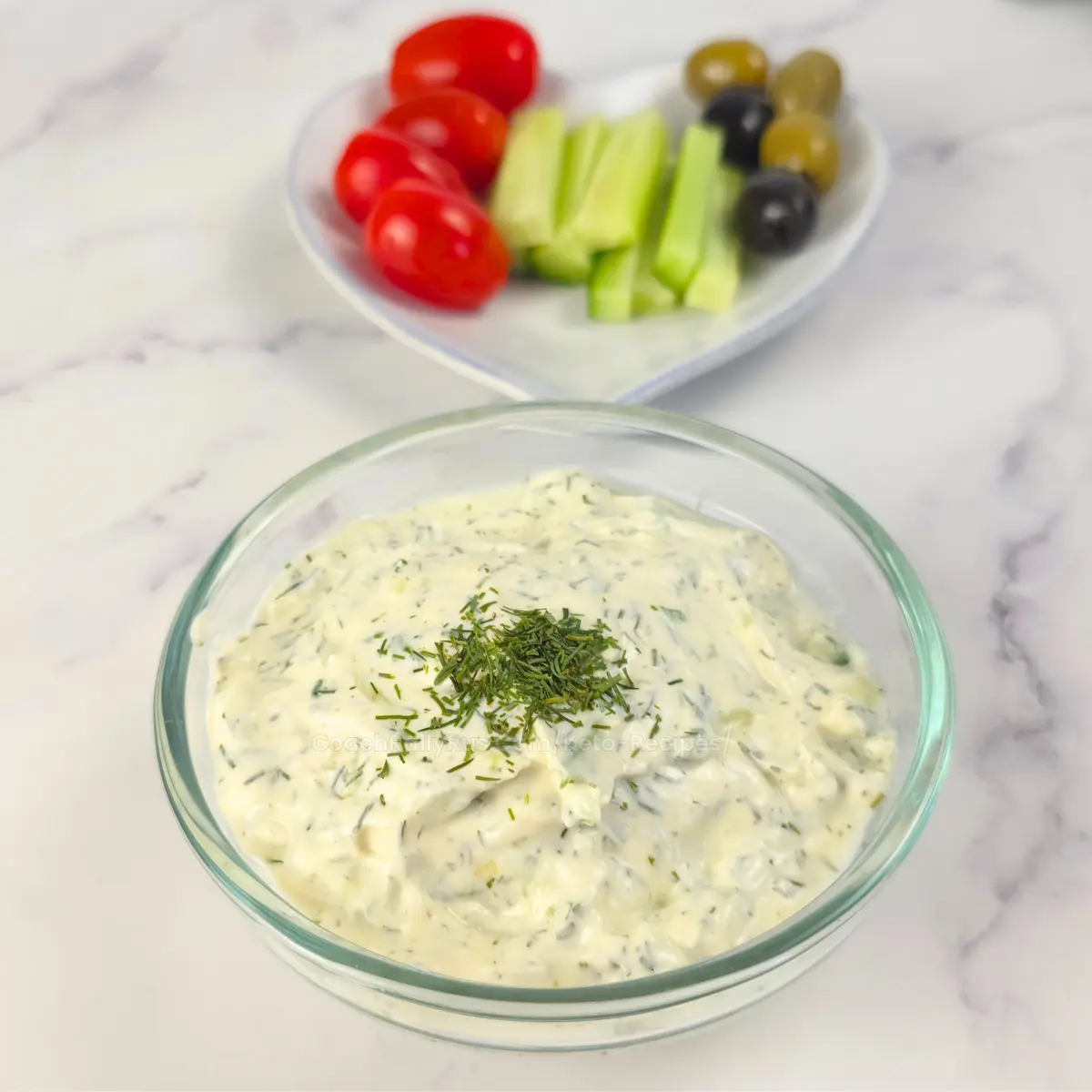 Sour cream tzatziki in a bowl with veggies on the side