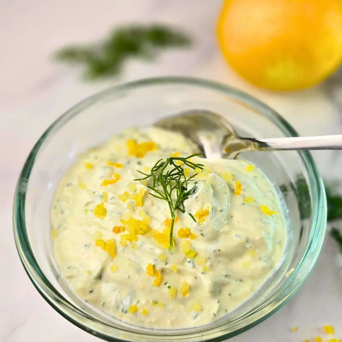 Creamy keto lemon dill cottage cheese sauce in a glass bowl with fresh dill and lemon zest