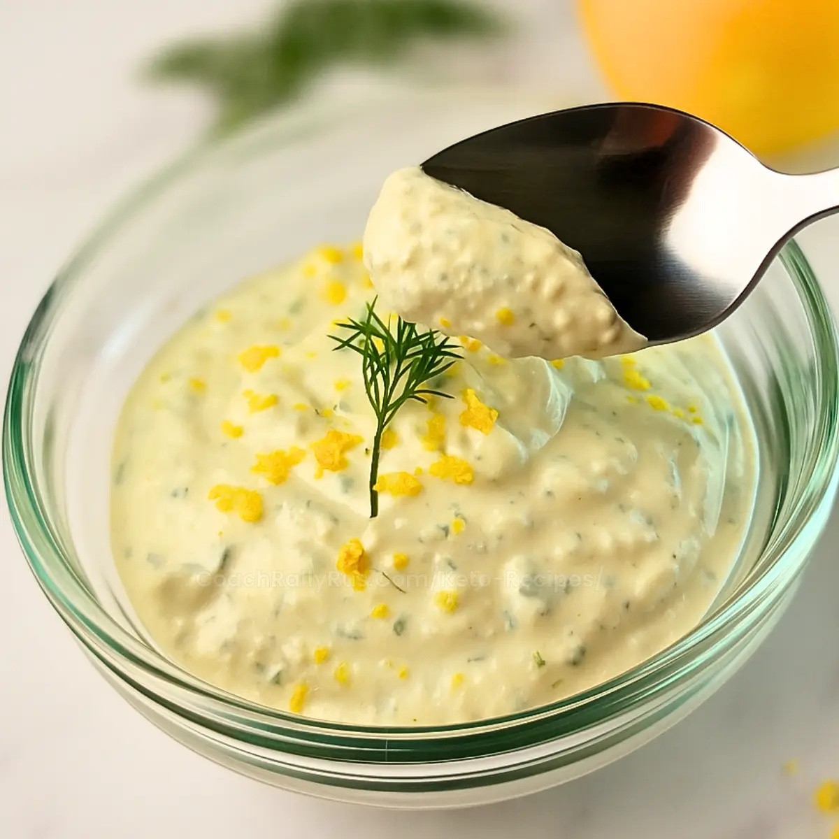 Overhead view of lemon dill cottage cheese sauce with herbs and lemon