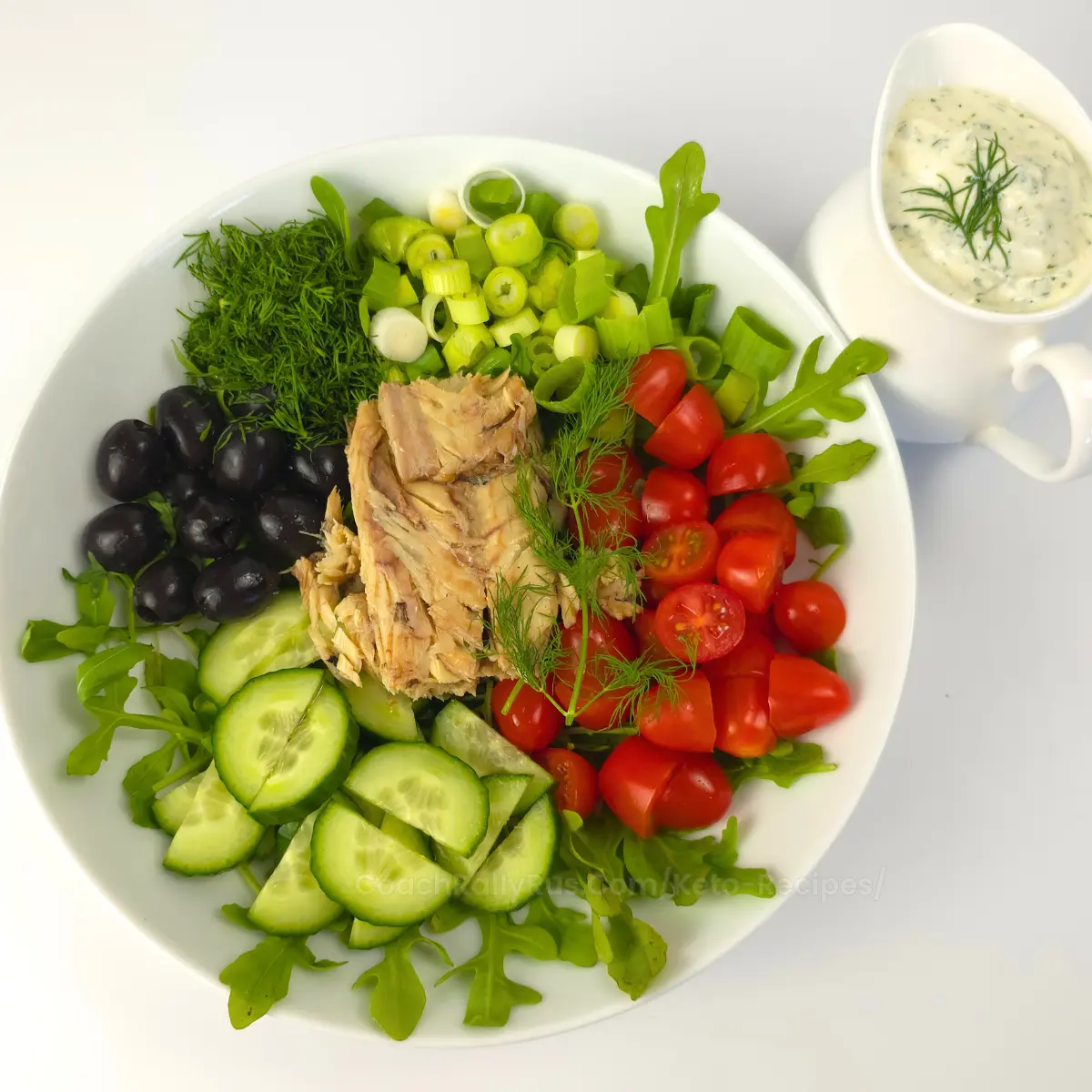 Cottage cheese mackerel salad in a white bowl with fresh herbs