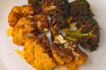 Mixed roasted broccoli and cauliflower on white speckled plate
