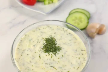 Close-up of creamy keto tzatziki sauce with dill garnish