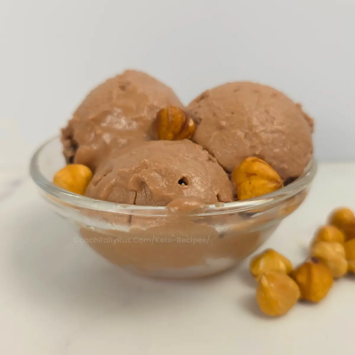 Creamy keto Nutella cottage cheese ice cream scoops in a clear bowl.