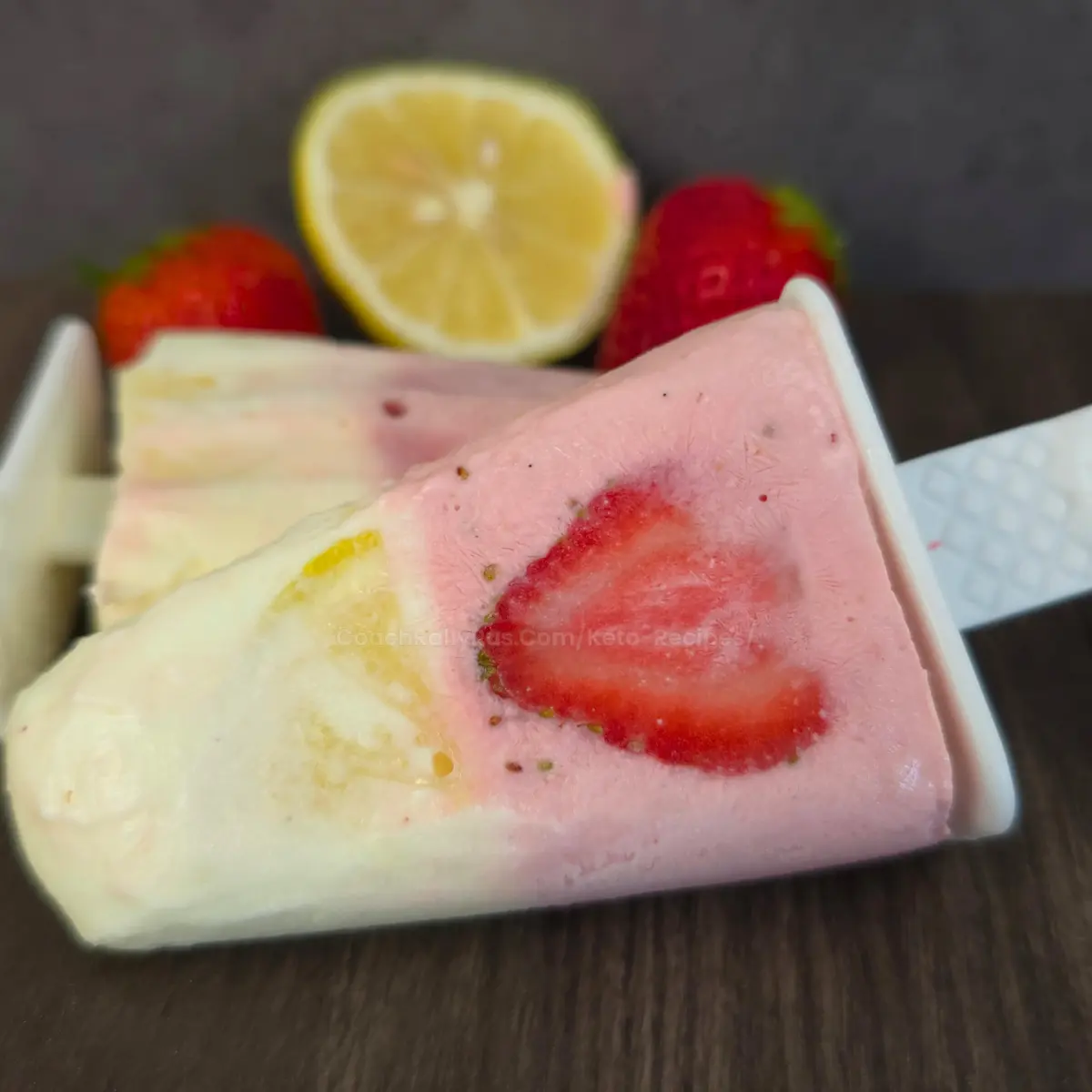 Keto popsicle with fresh strawberry and lemon slices on dark background