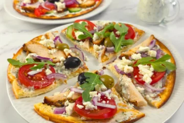 Sliced cottage cheese flatbread pizza with tzatziki and chicken gyros