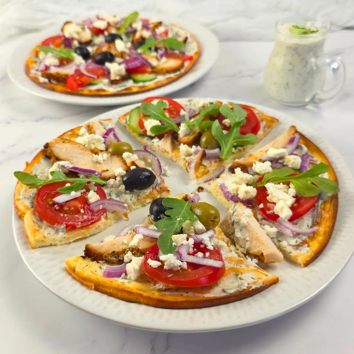 Sliced cottage cheese flatbread pizza with tzatziki and chicken gyros