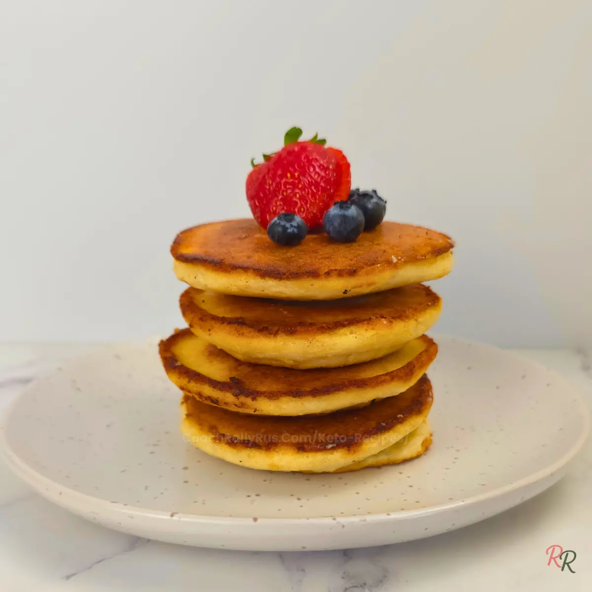 Plain stack of keto almond flour pancakes with berries on top